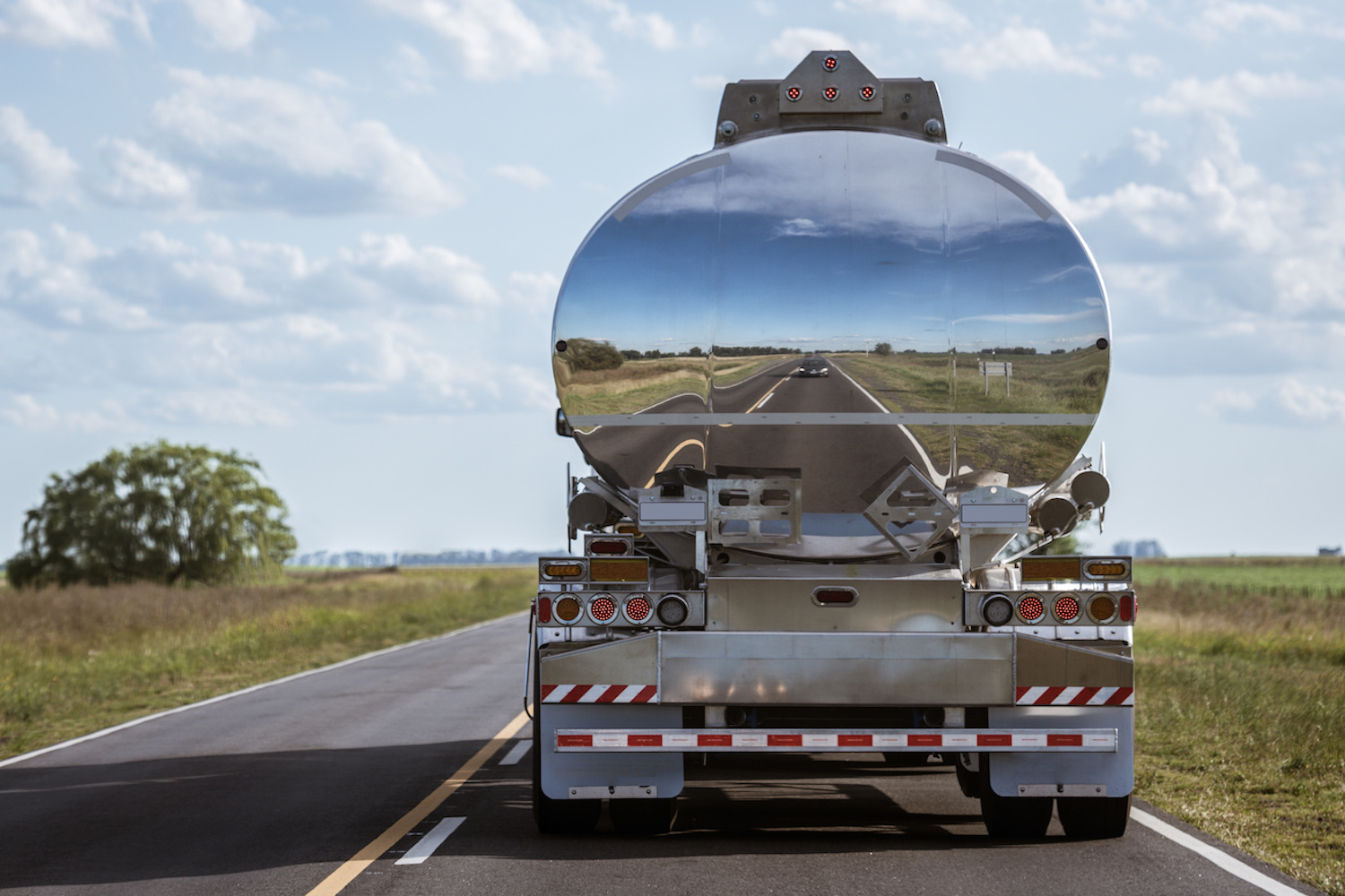 A truck tank of gasoline with reflection on the road